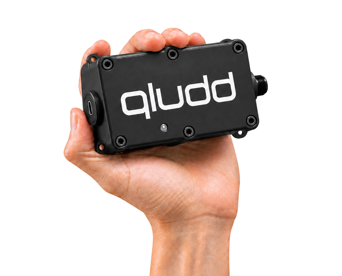 A hand holding the compact qludd marine data device